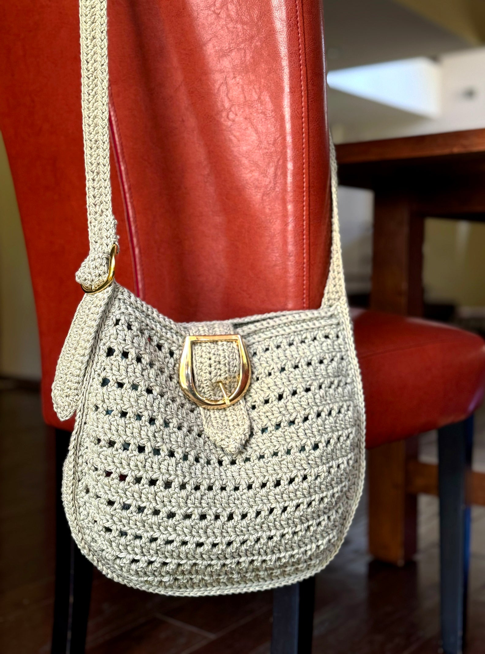 70's inspired, the Livia bag is a cross body crocheted bag with adjustable strap and brass buckle closure. Color: Light Olive Dimensions: 12" Long, 11" High, 25" Strap length from shoulder Adjustable Strap: Can be adjusted 4" shorter or longer Consciously crafted in California