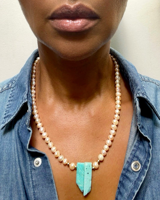 Fresh water, champagne pearl necklace with gold filled beads and Amazonite pendant. Pearls promote purity, faith, loyalty and truth, and is the birthstone of the astrological sign Gemini. Amazonite, known for creativity, goal setting and truth, is a must for artists, teachers, and anyone who leans into their creative side. A show stopper on it's own, or layer it for more gorgeousness. Dimensions: 19.5 inches, Pearls: 5/6mm, Amazonite: 1 inch Consciously made in California