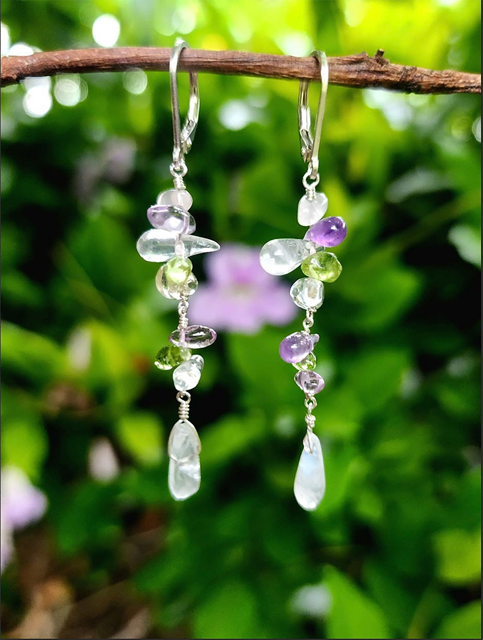 Boost your well being in these gorgeous gemstone drop earrings with healing properties of Moonstone, emotional balance of Amethyst, and immune support of Peridot. Beautifully layered in various teardrop shapes. Available in either gold-filled or silver with lever backs. Handcrafted by Randi M. exclusively for Handmade on MarVia Square. Custom variations of gemstones can be made upon request. Dimensions: Length: 2" Clean with soft brush or cloth, using mild dish soap and lukewarm water Made in California