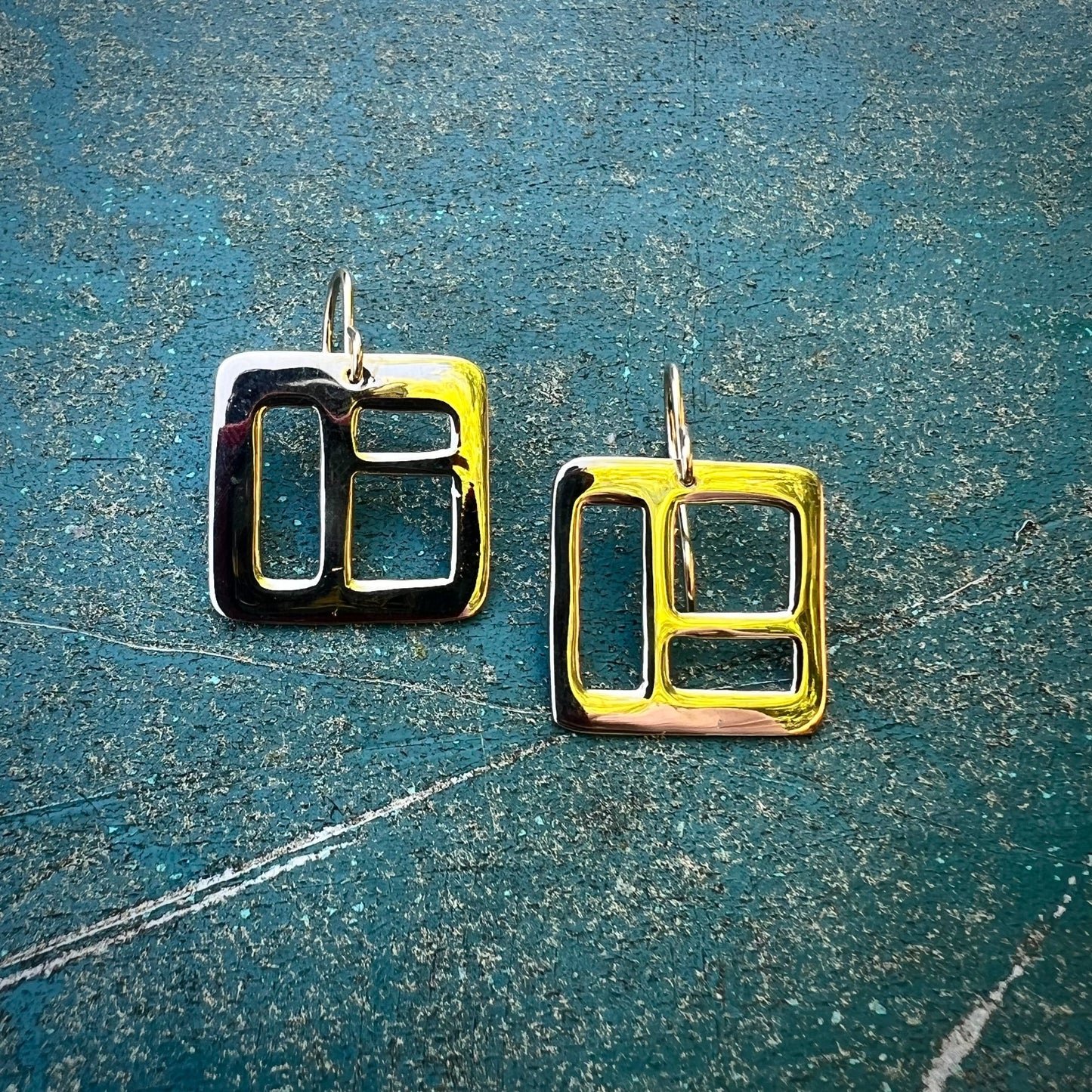 The Windowpane Earrings are delicate, lightweight and striking. Available in sterling silver and brass, each pair is asymmetrical and features small geometric cut-outs. Clean with polishing pad or soft cloth and mild soap. Consciously made in New York.