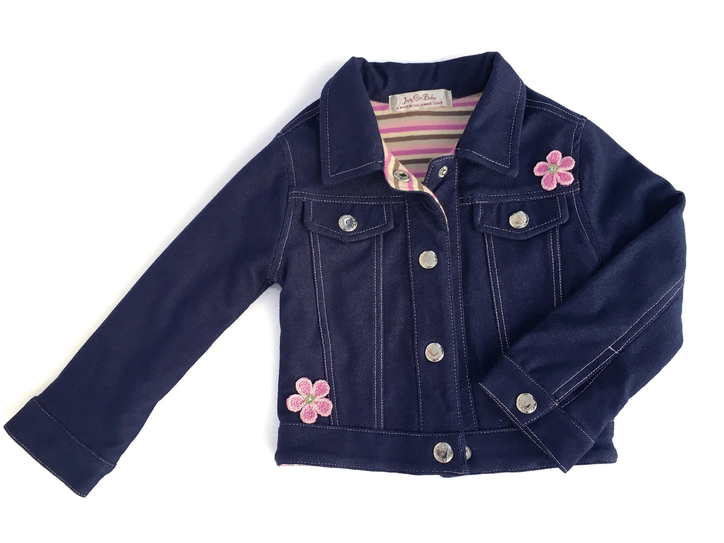 The softest denim jacket with embroidered pink daisies and pink top stitching. Fully lined with 100% cotton knit, in a pink stripe pattern. Crocheted pink daisies appliqued on front of jacket. Nickel free, silver snap closures for easy on and off. Complete the look with a pair of Denim & Daisies Jeans and your little one will be the cutest dressed for line dancing. Order a size larger for longer wear Denim Knit - 85% Cotton, 15% Lycra Machine washable, cold, delicate cycle (inside out to protect embroidery)